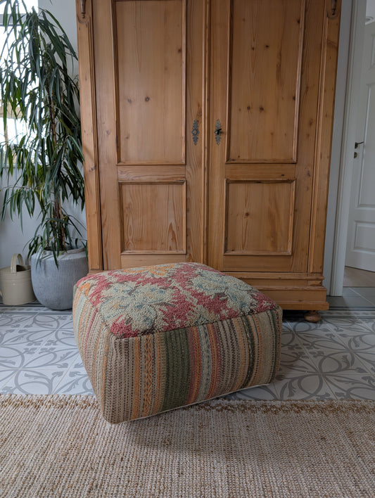 Pouf tuffed wool with filler. Red orange with stribes in the side.